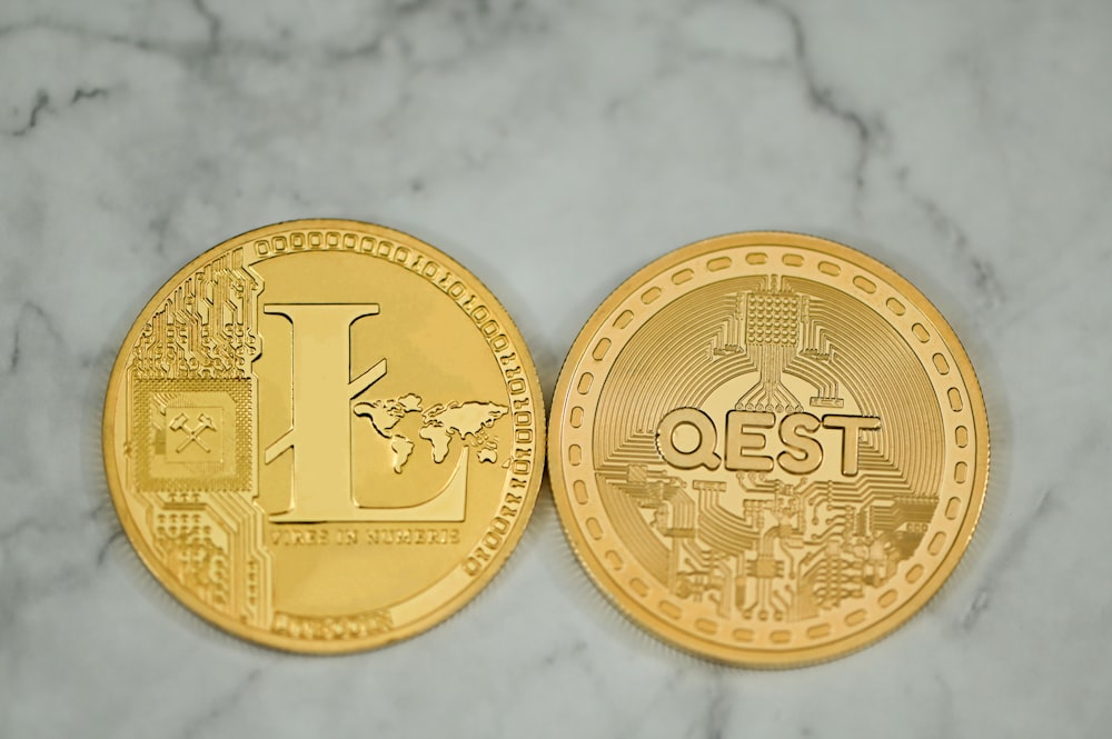 a close up of two gold coins on a marble surface