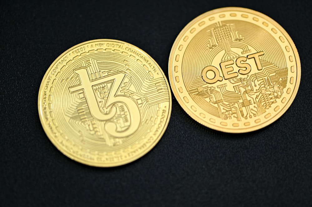 a close up of two gold coins on a black surface