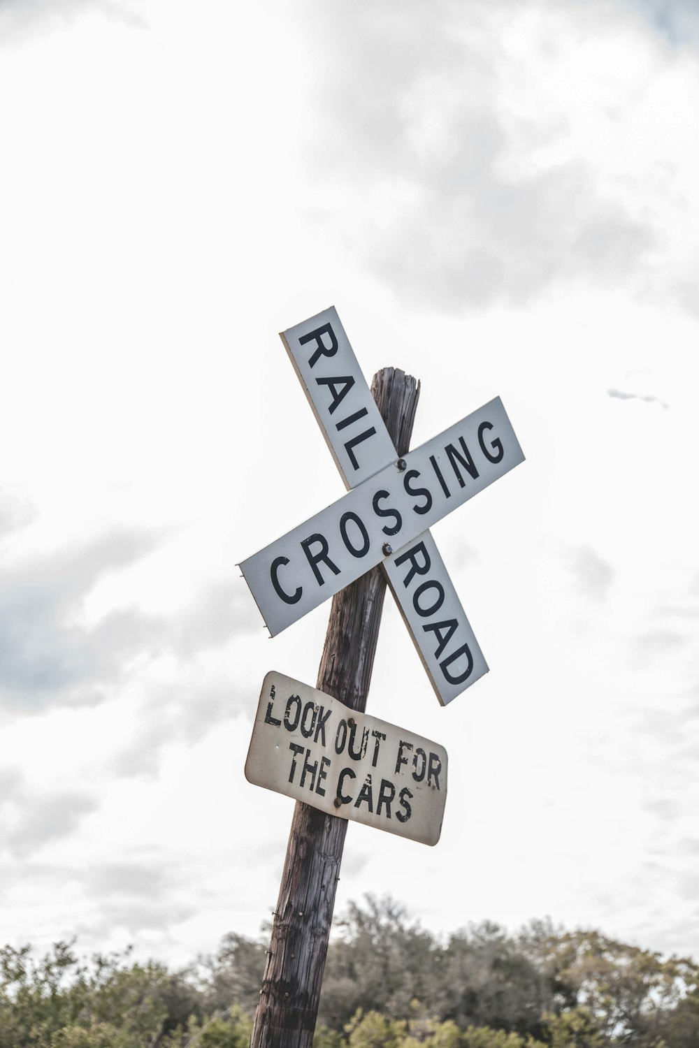 a railroad crossing sign on top of a wooden pole