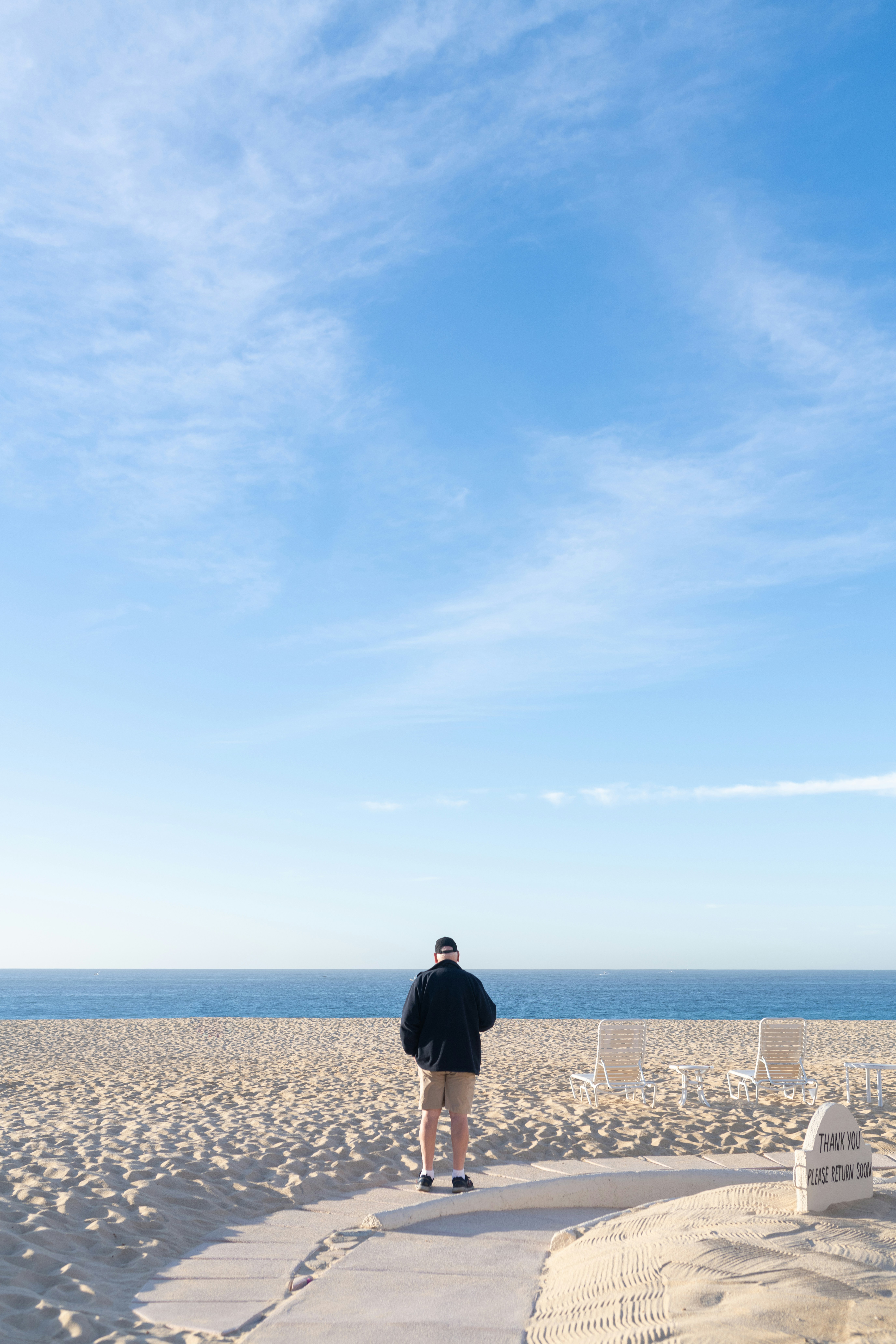 a man standing on a beach next to the ocean