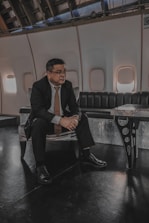 a man in a suit and tie sitting on a bench
