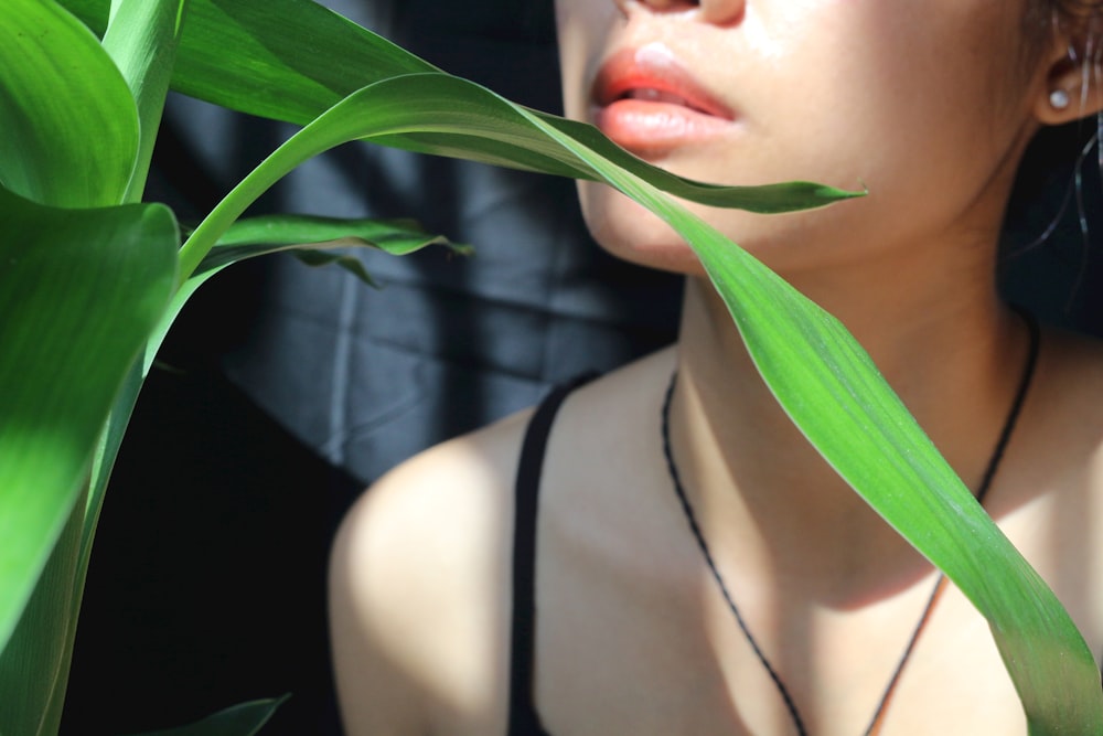 a woman with red lipstick and a green plant