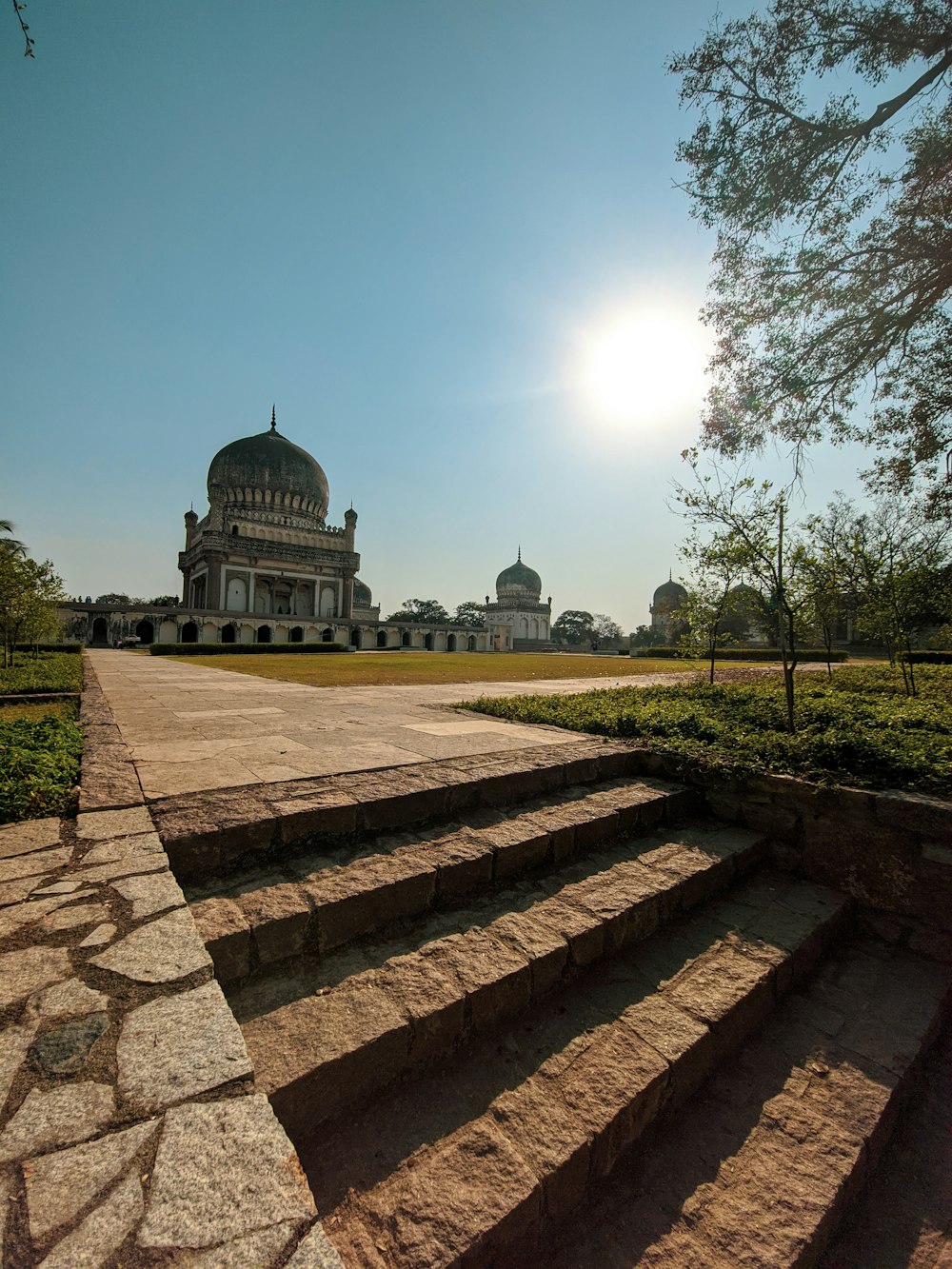 a stone staircase leading to a building with a dome in the background