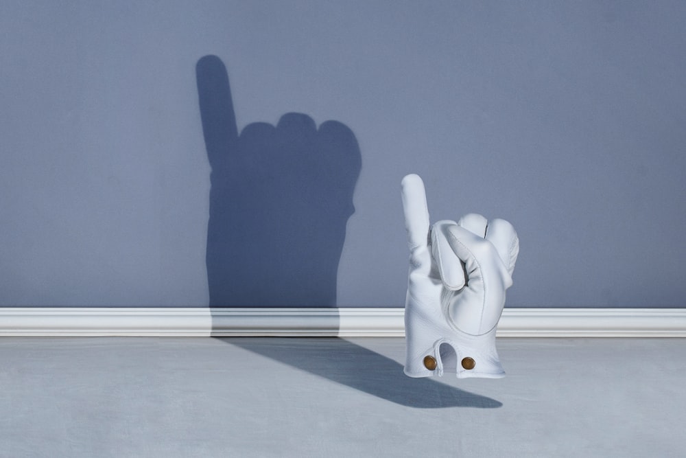 a sculpture of a hand casting a shadow on a wall