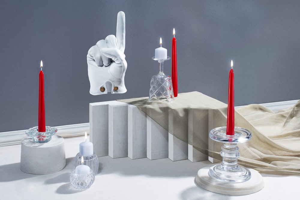 a table with candles and a sculpture of a hand