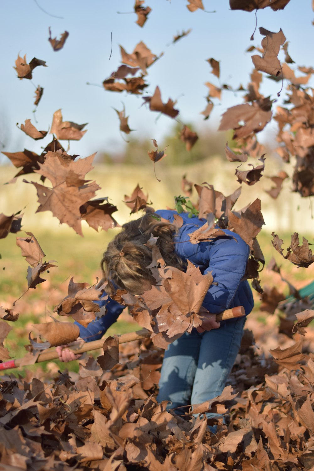 a little girl playing in a pile of leaves