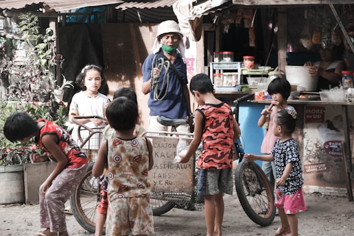 a group of young children standing around a bicycle
