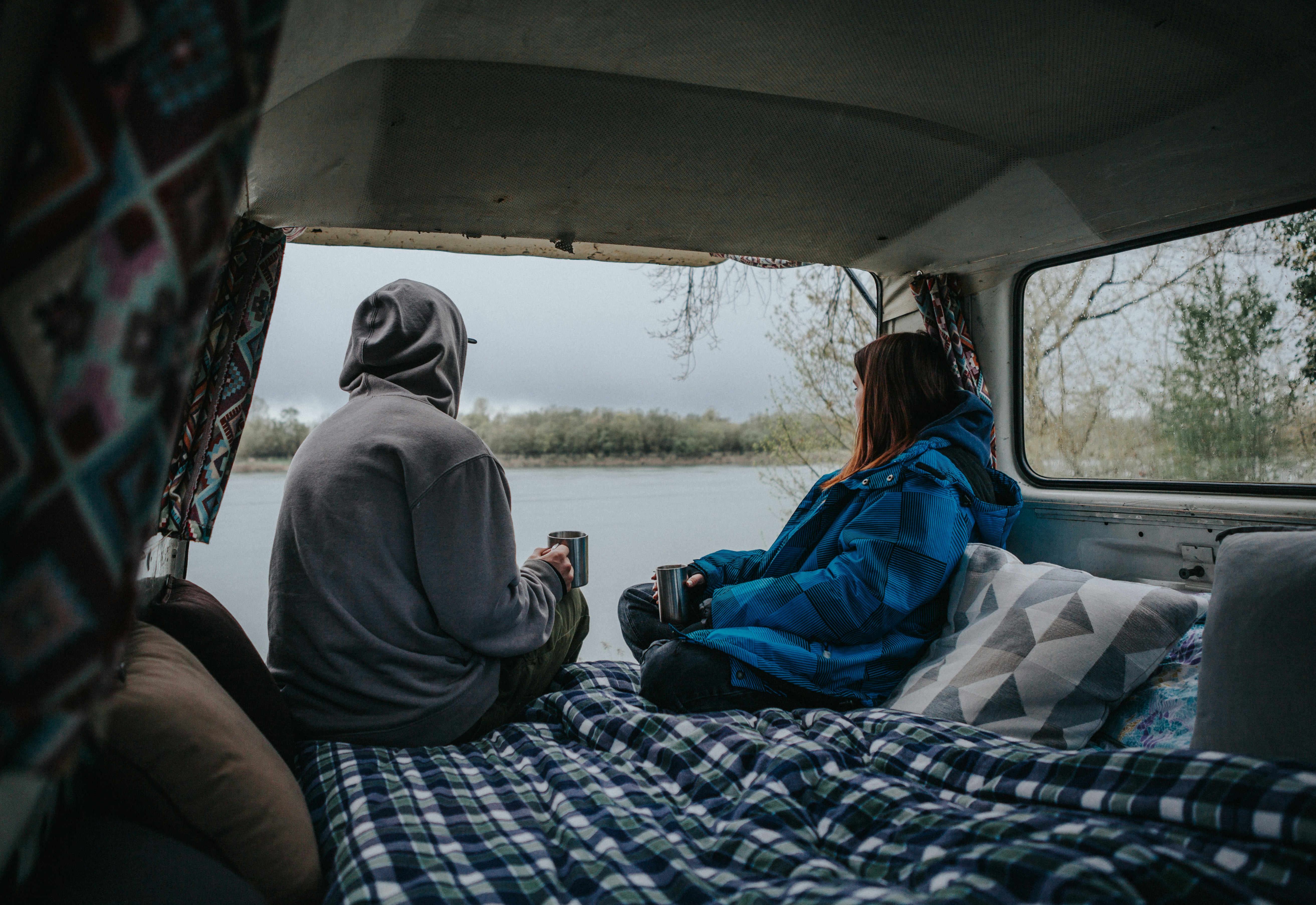 two people sitting on a bed in the back of a truck, 