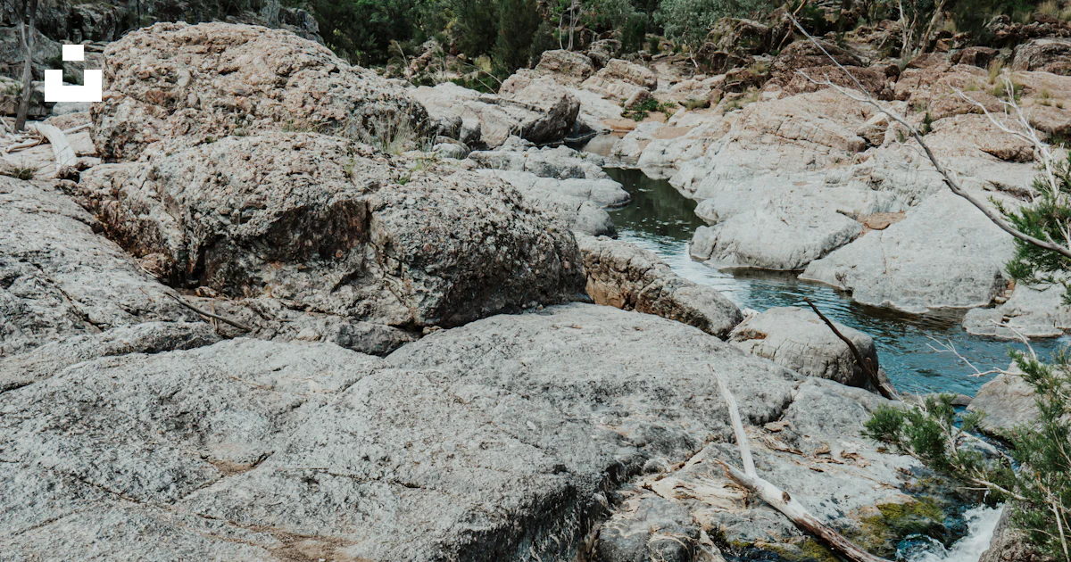 Stream Between Two Rocks A river flowing between two large rocks photo – Free Ancient geological ...