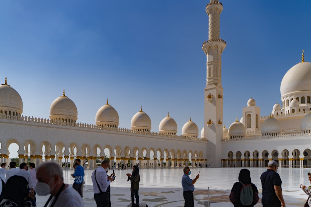 a group of people standing in front of a white building