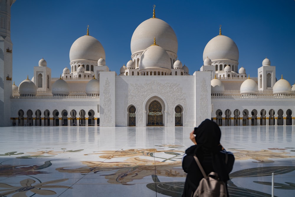 a woman standing in front of a white building