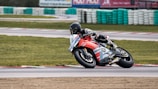 A rider leaning into a sharp corner on a racetrack, sportbike equipped with fortytwo performance upgrades.