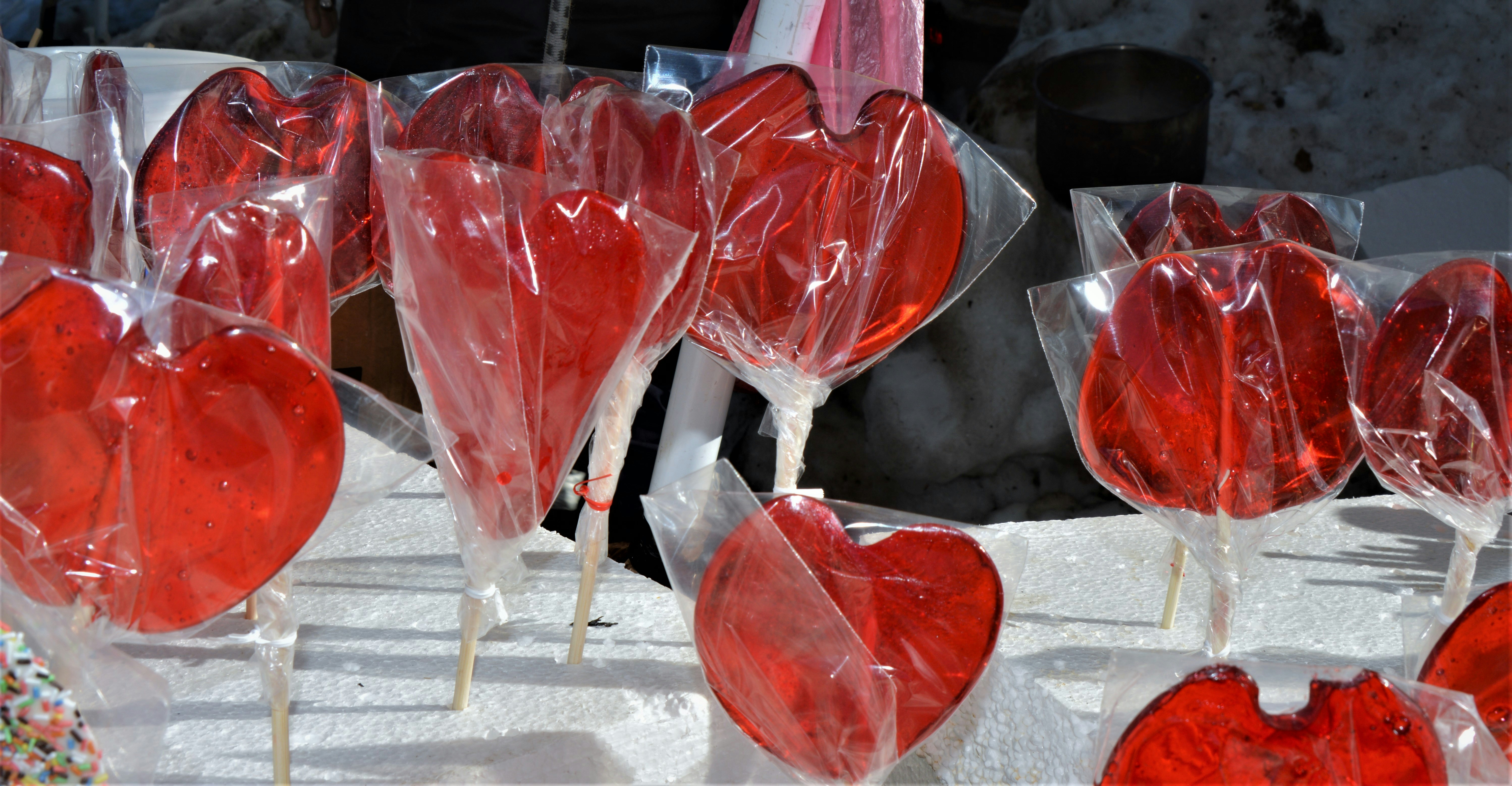 a bunch of heart shaped lollipops on a stick