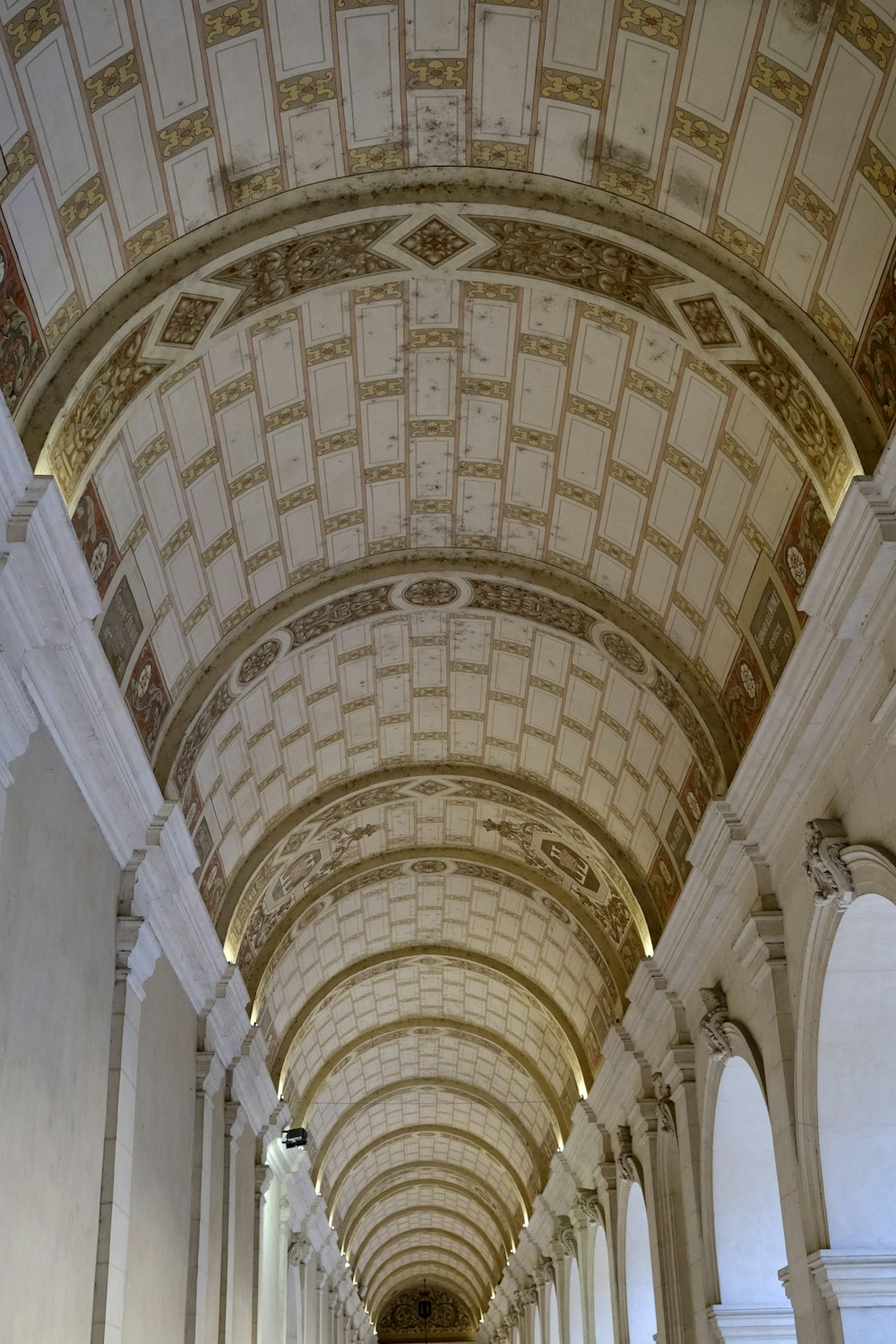 a long hallway in a building with arches and arches
