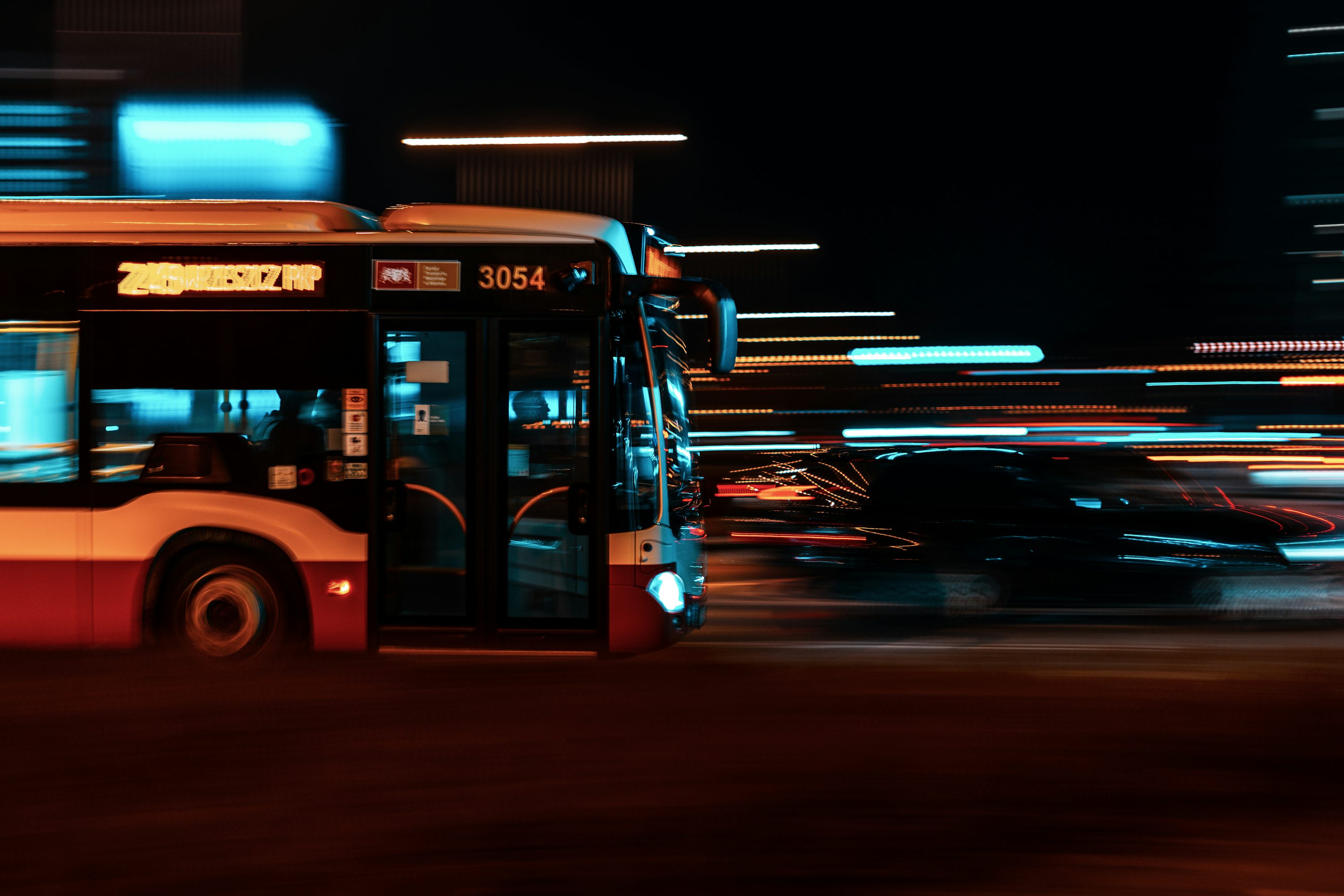 a city bus driving down a street at night