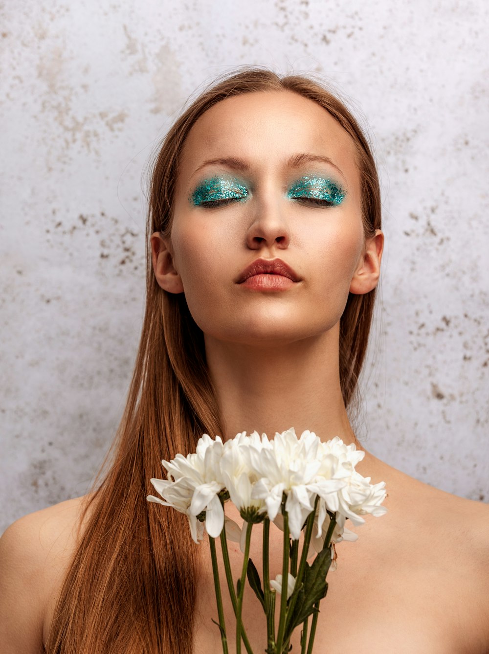 a woman with blue eyes holding a flower