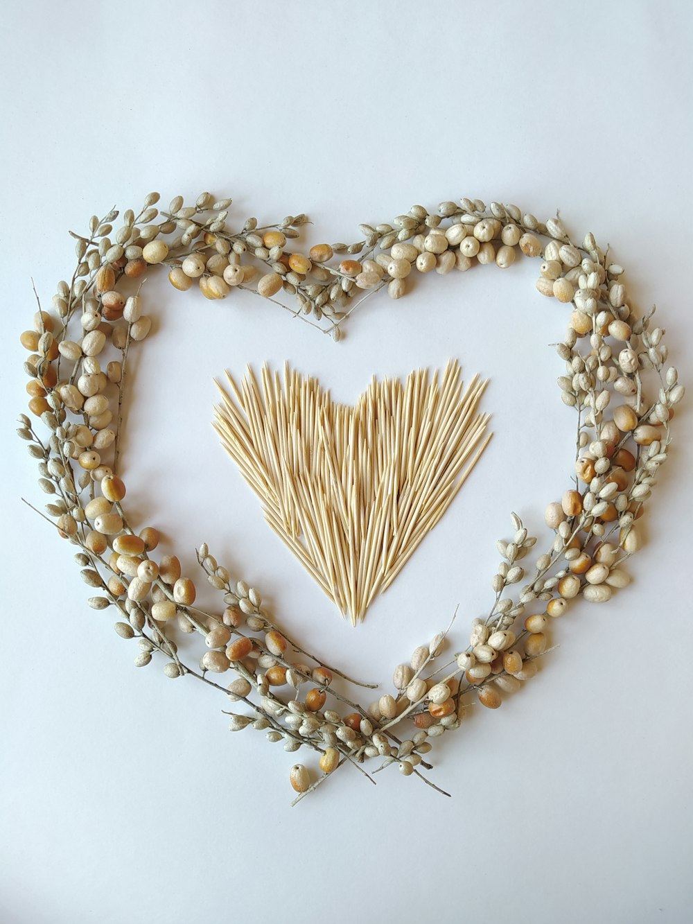 a heart made out of straw and dried flowers