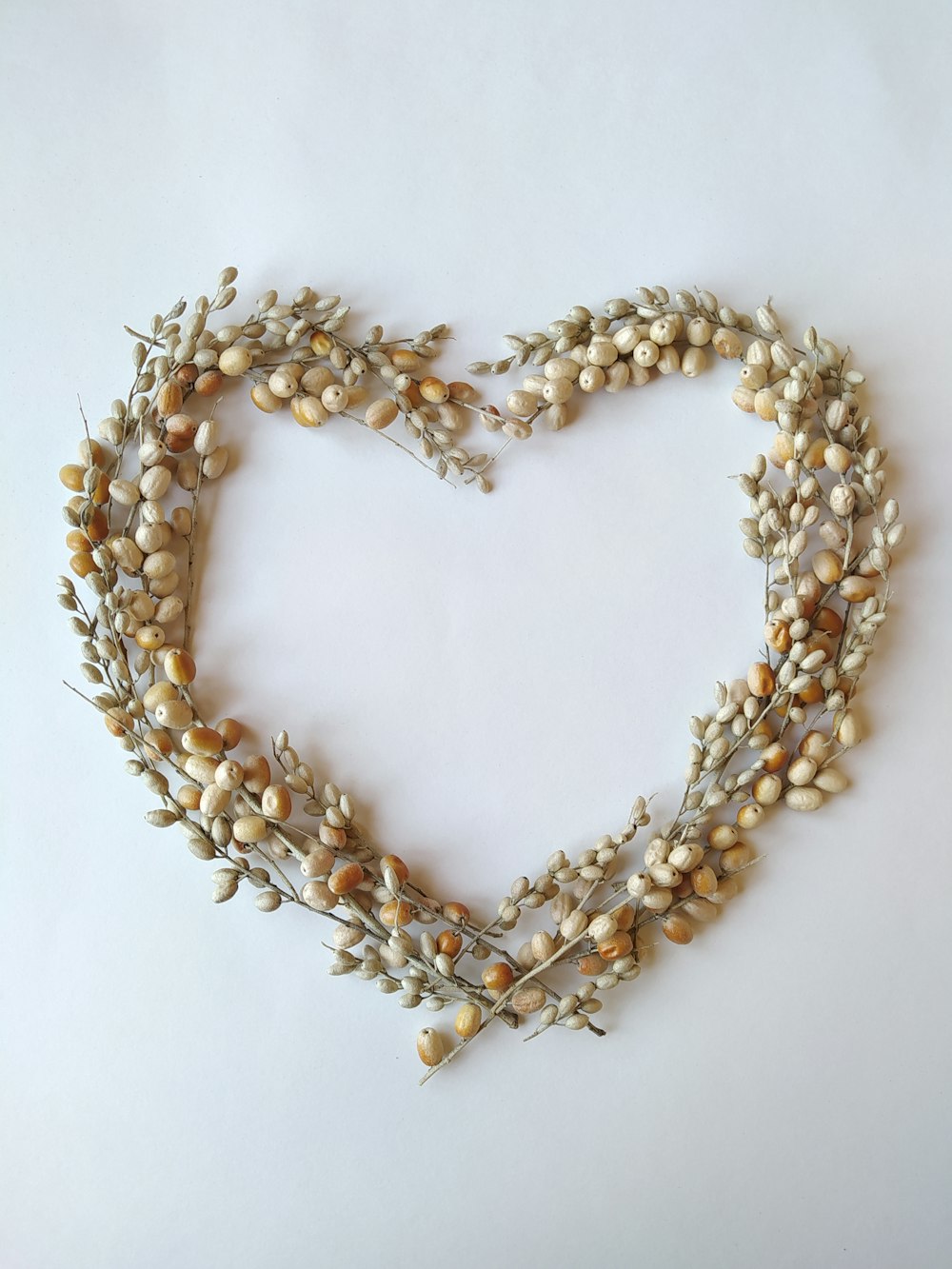 a heart shaped wreath made of dried flowers