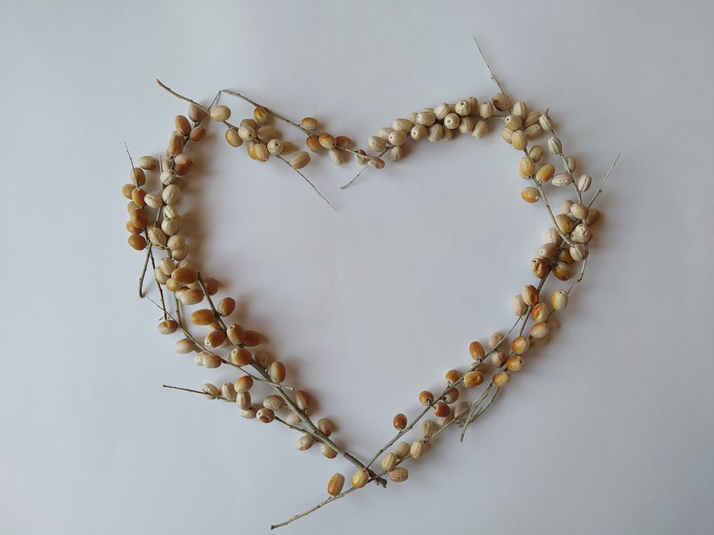 a heart shaped arrangement of dried flowers and leaves