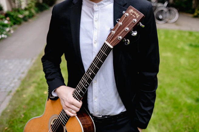a man in a suit holding a guitar