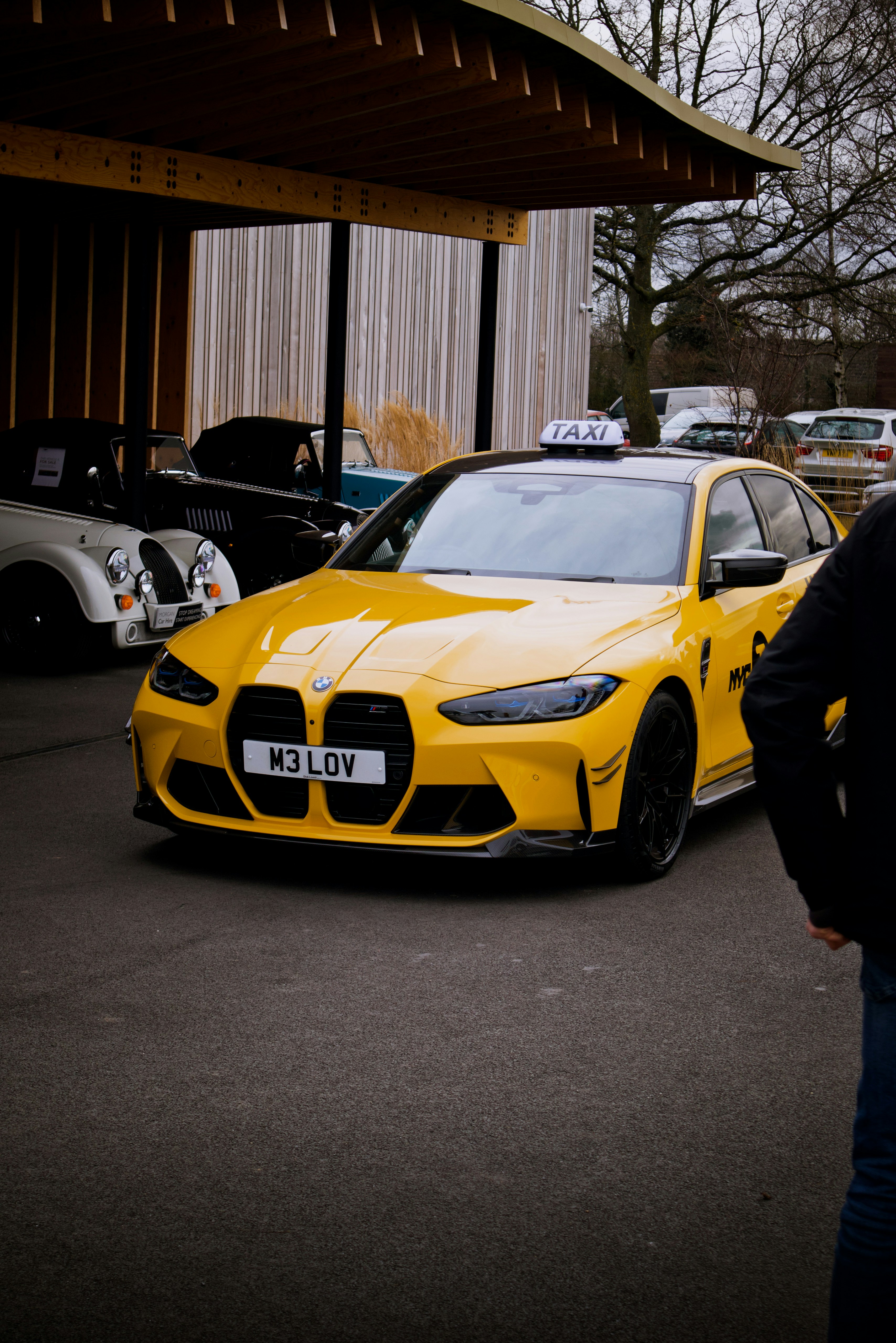 a man standing next to a yellow sports car