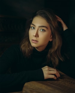 a woman with long hair sitting at a table