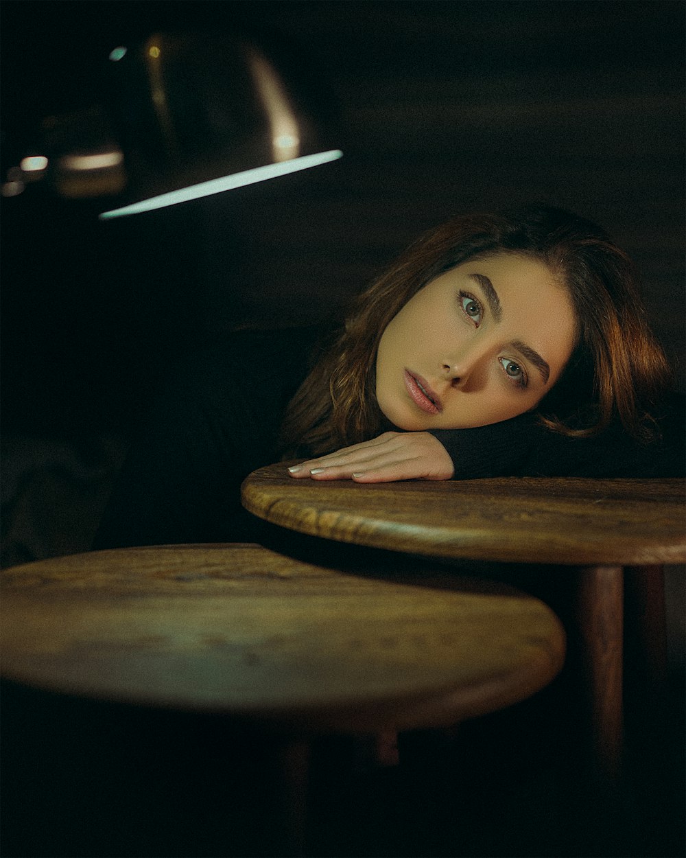 a woman leaning her head on a table