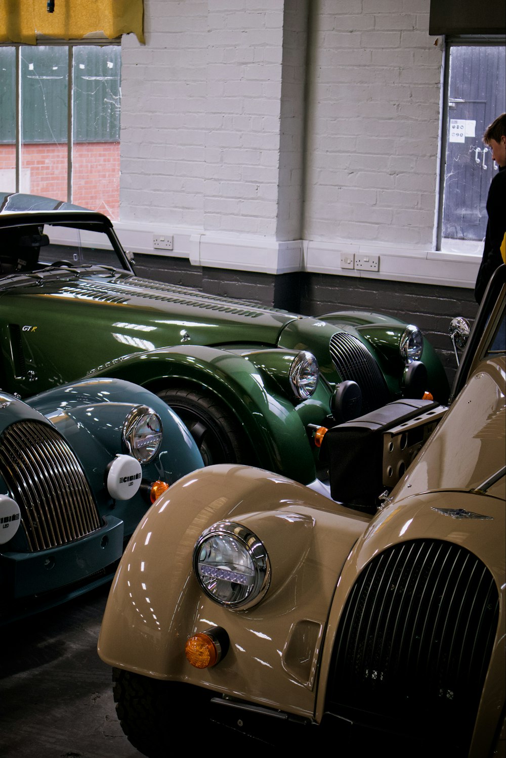 a man standing next to a car in a garage