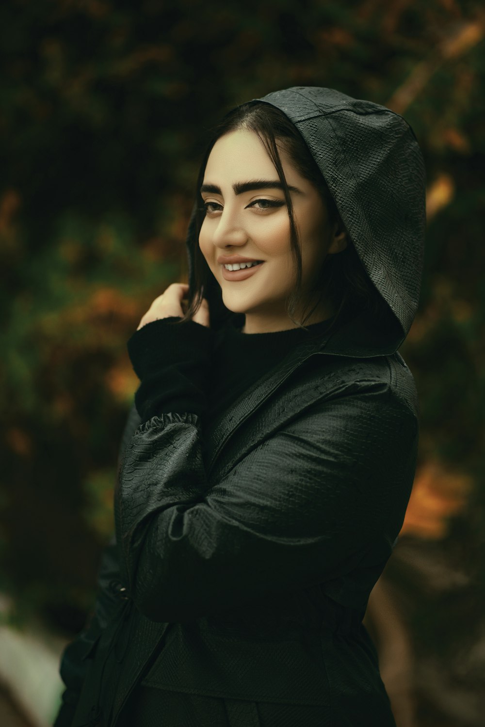 a woman in a black coat is smiling