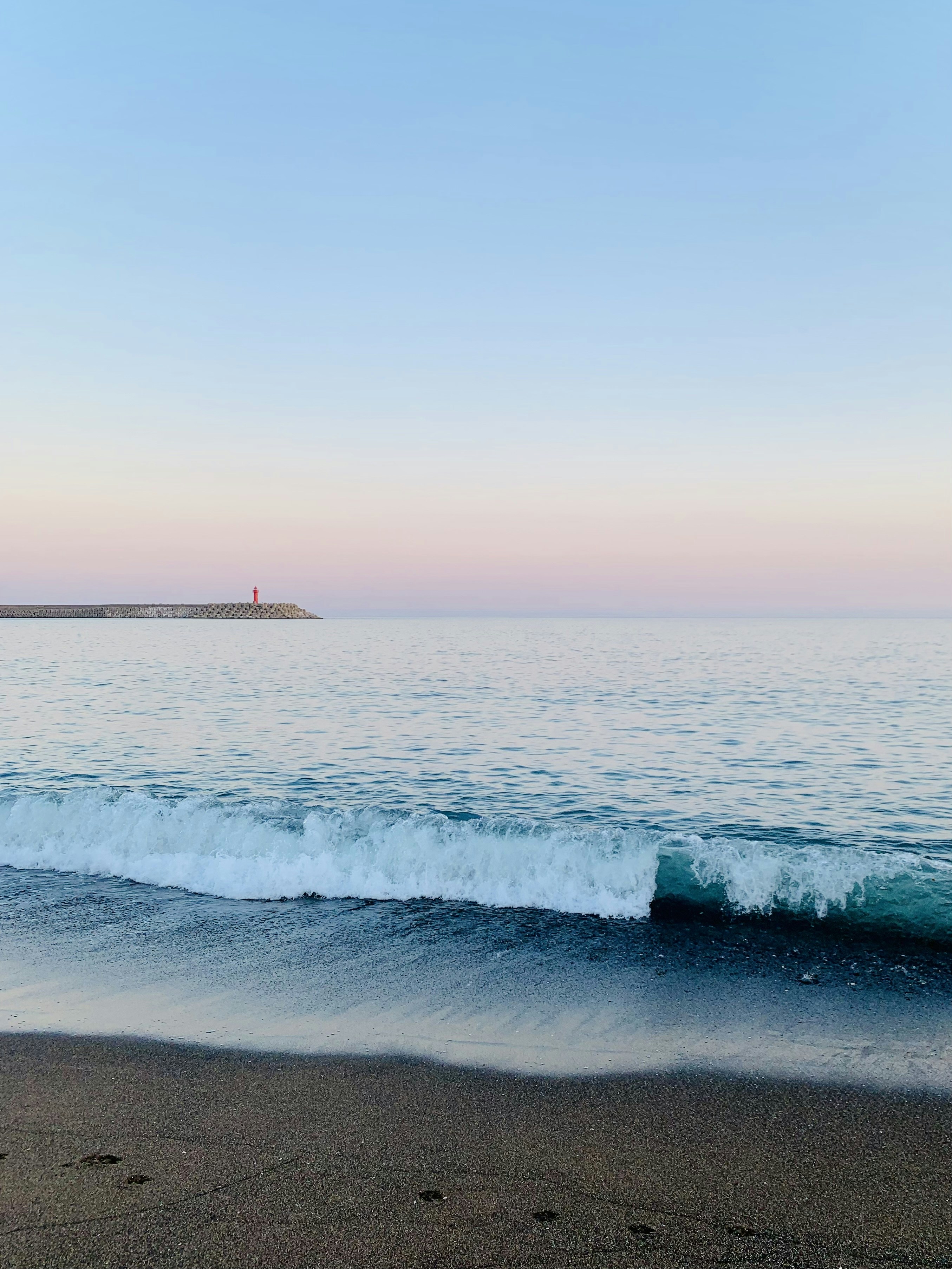 a body of water sitting next to a sandy beach