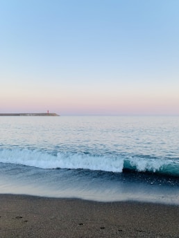 a body of water sitting next to a sandy beach