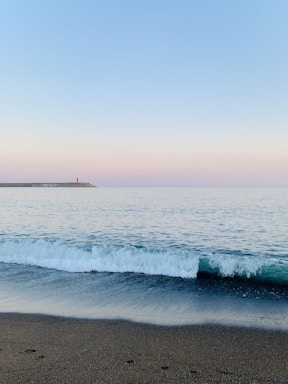 a body of water sitting next to a sandy beach
