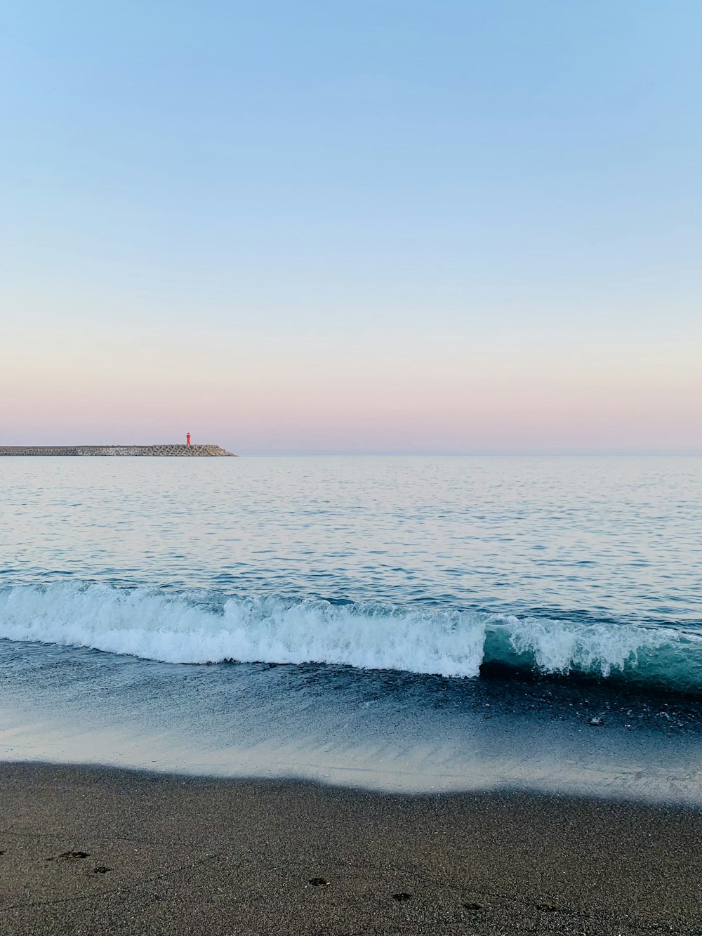 a body of water sitting next to a sandy beach