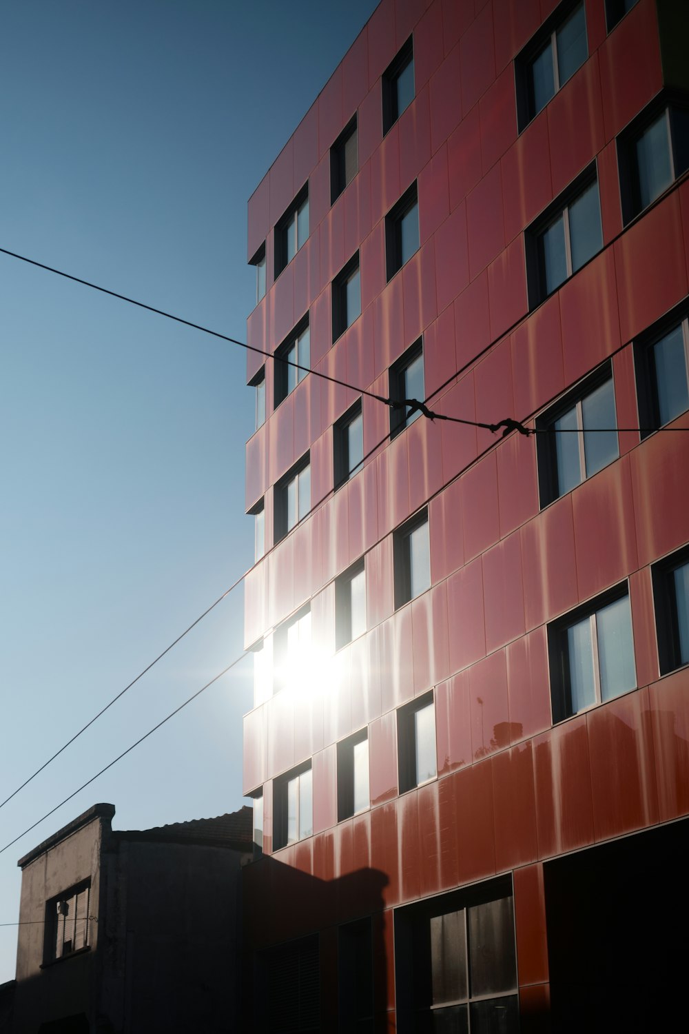 a tall red building sitting next to a power line