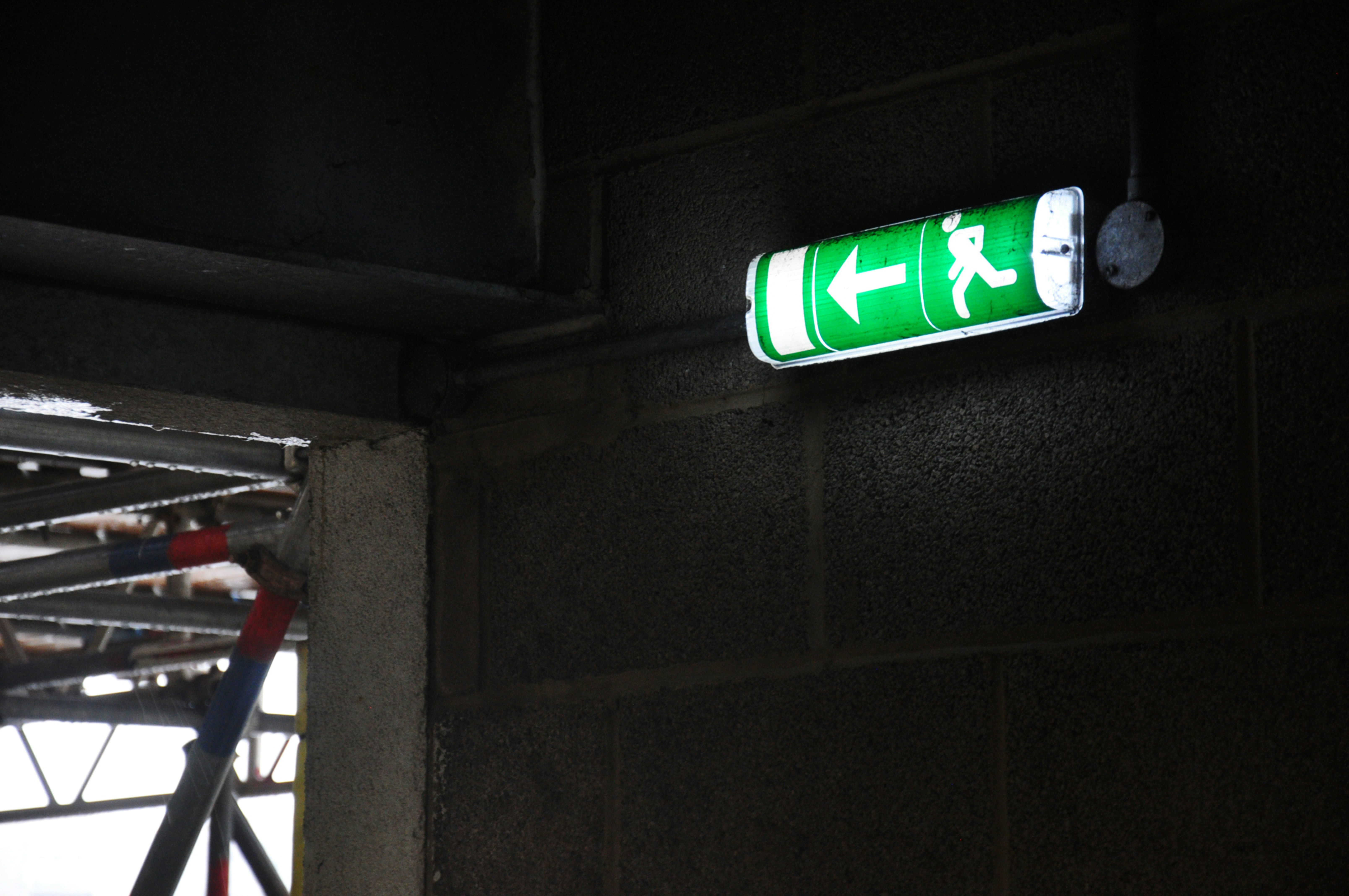 un panneau vert qui se trouve sur le côté d’un bâtiment