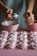 a person scooping icing from a spoon into a bowl