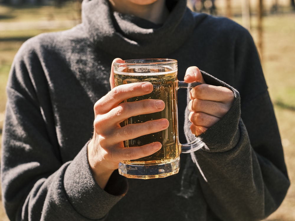 a woman holding a glass of beer in her hands