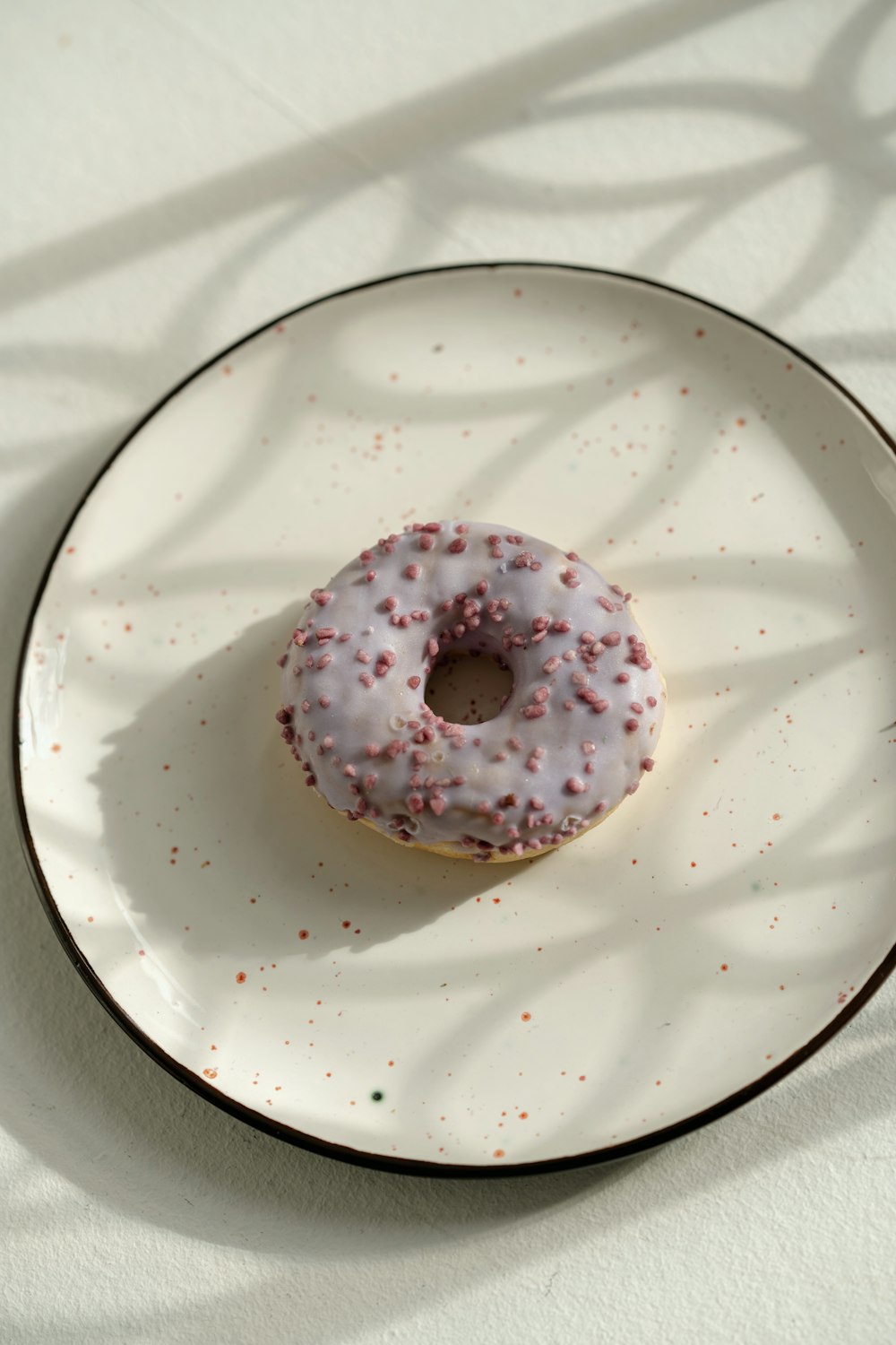 um donut em um prato branco com polvilhos