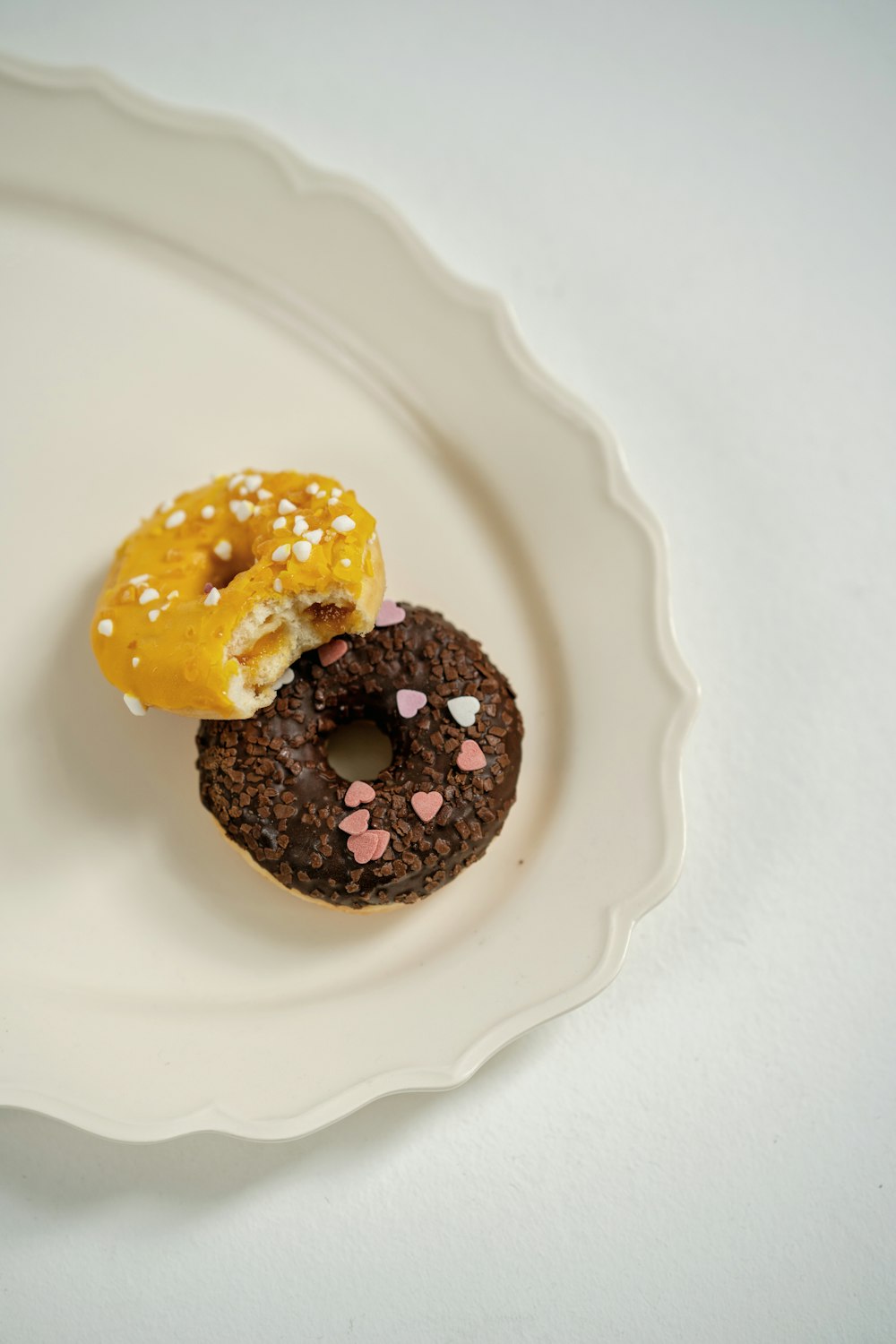 a couple of doughnuts sitting on top of a white plate