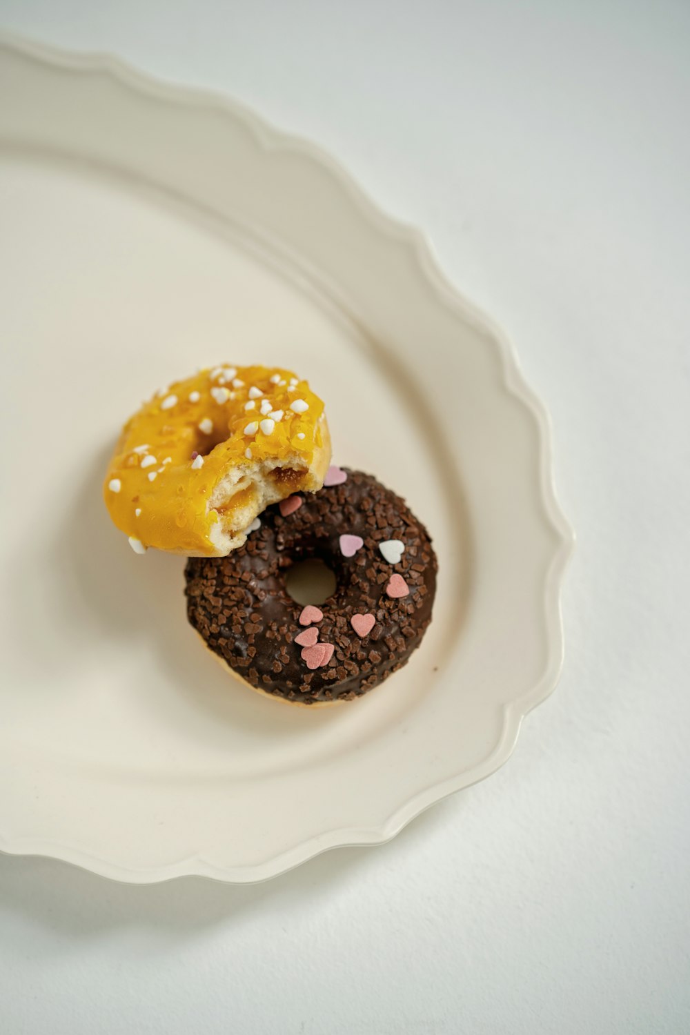 a couple of doughnuts sitting on top of a white plate