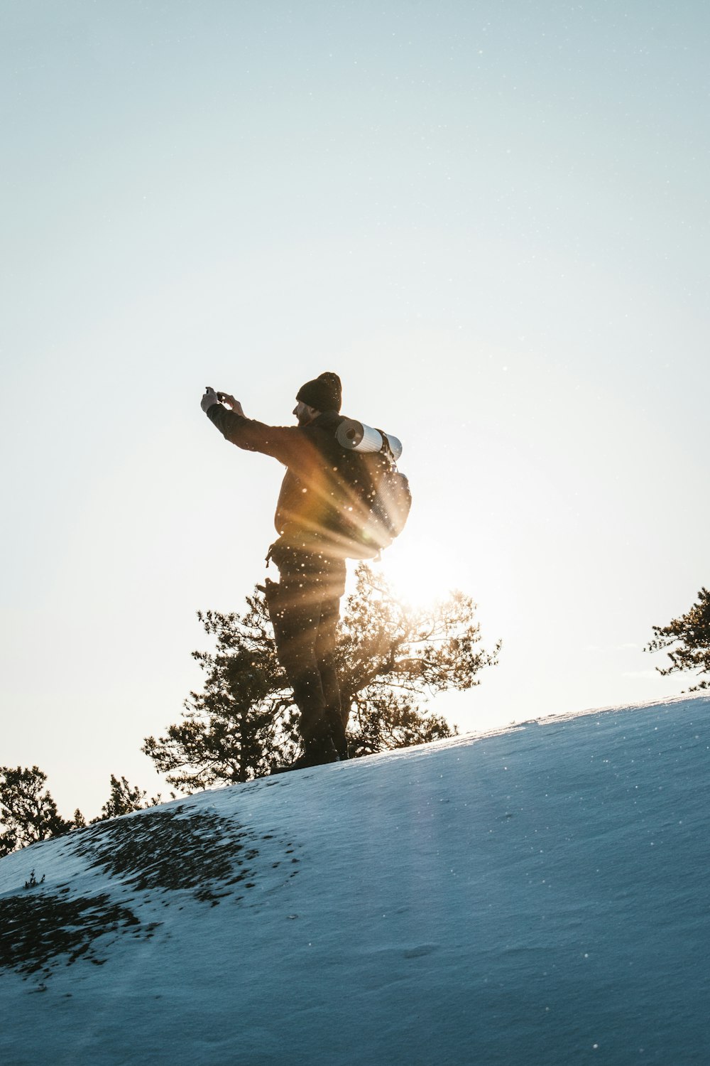 Ein Mann fährt mit einem Snowboard einen schneebedeckten Hang hinunter