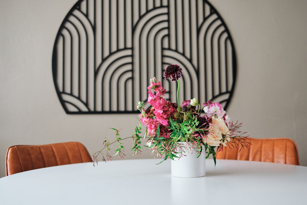a white table with a vase of flowers on top of it