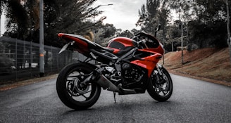 a red motorcycle parked on the side of a road