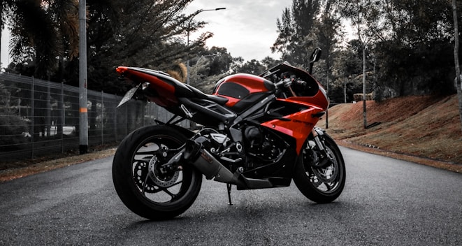 a red motorcycle parked on the side of a road