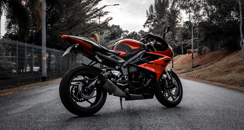 a red motorcycle parked on the side of a road