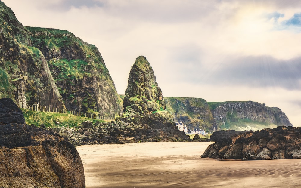 a beach with a rock formation in the middle of it