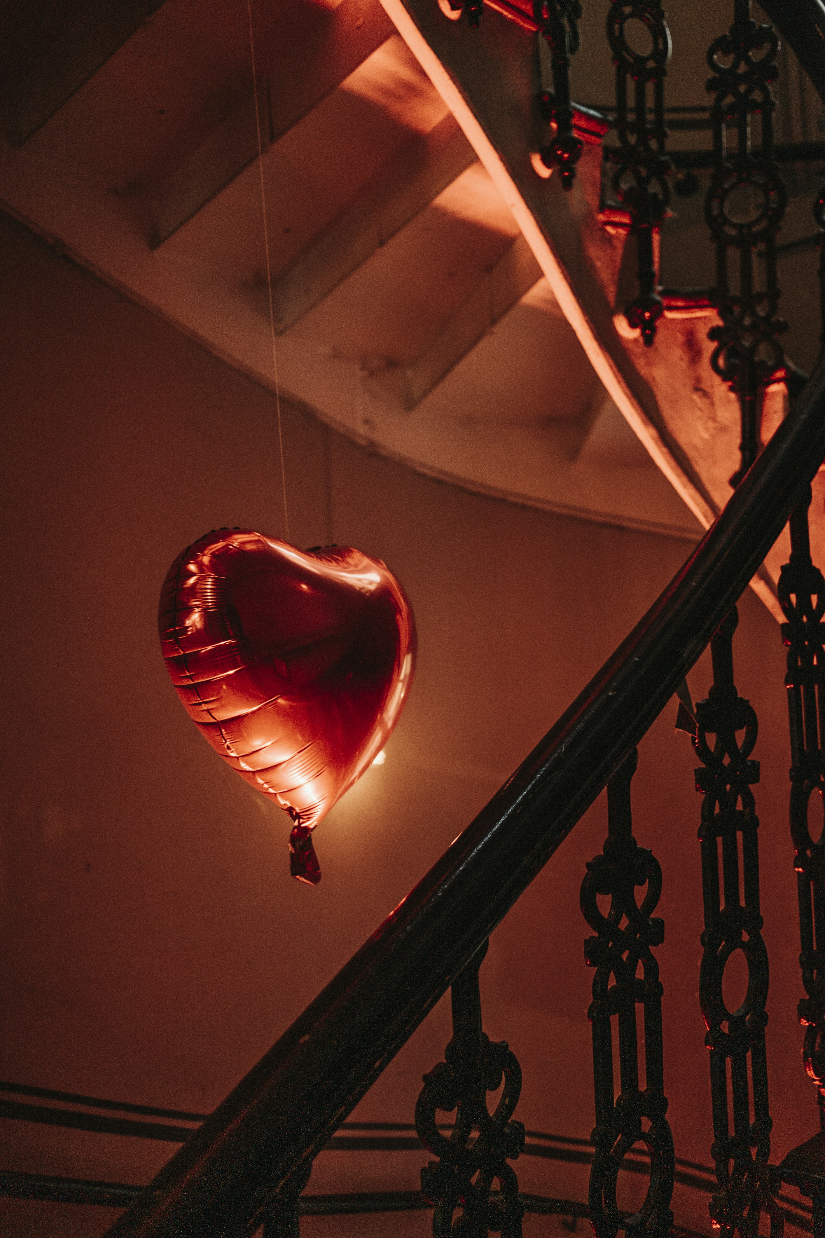 a heart shaped balloon hanging from a railing