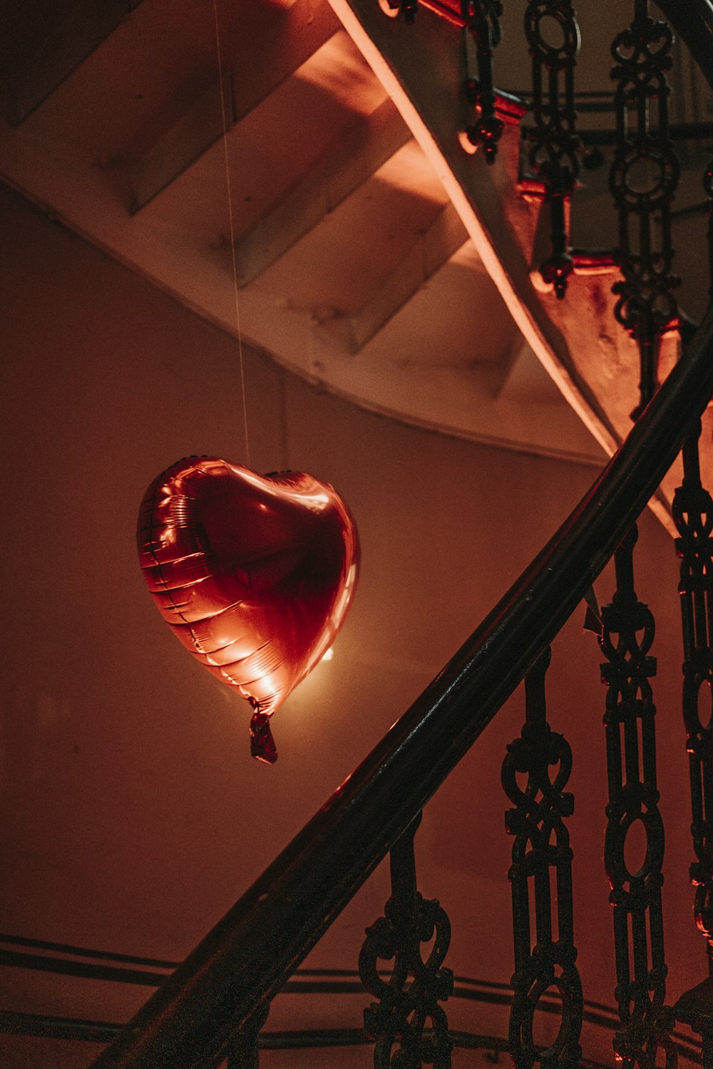 a heart shaped balloon hanging from a railing