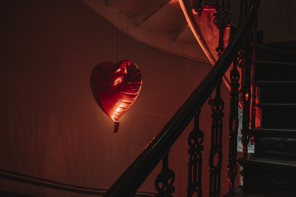 a heart shaped light hanging from the side of a staircase