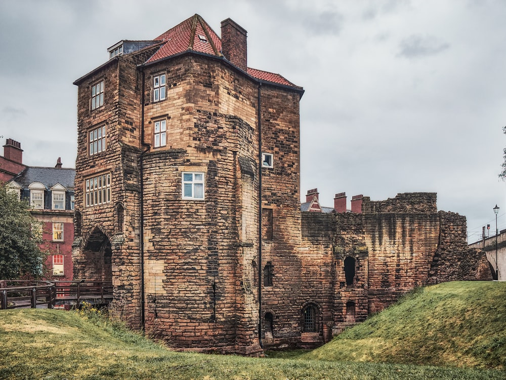 a tall brick building sitting on top of a lush green field